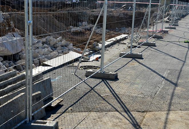 protective barrier made of temporary fence panels being erected around a job site